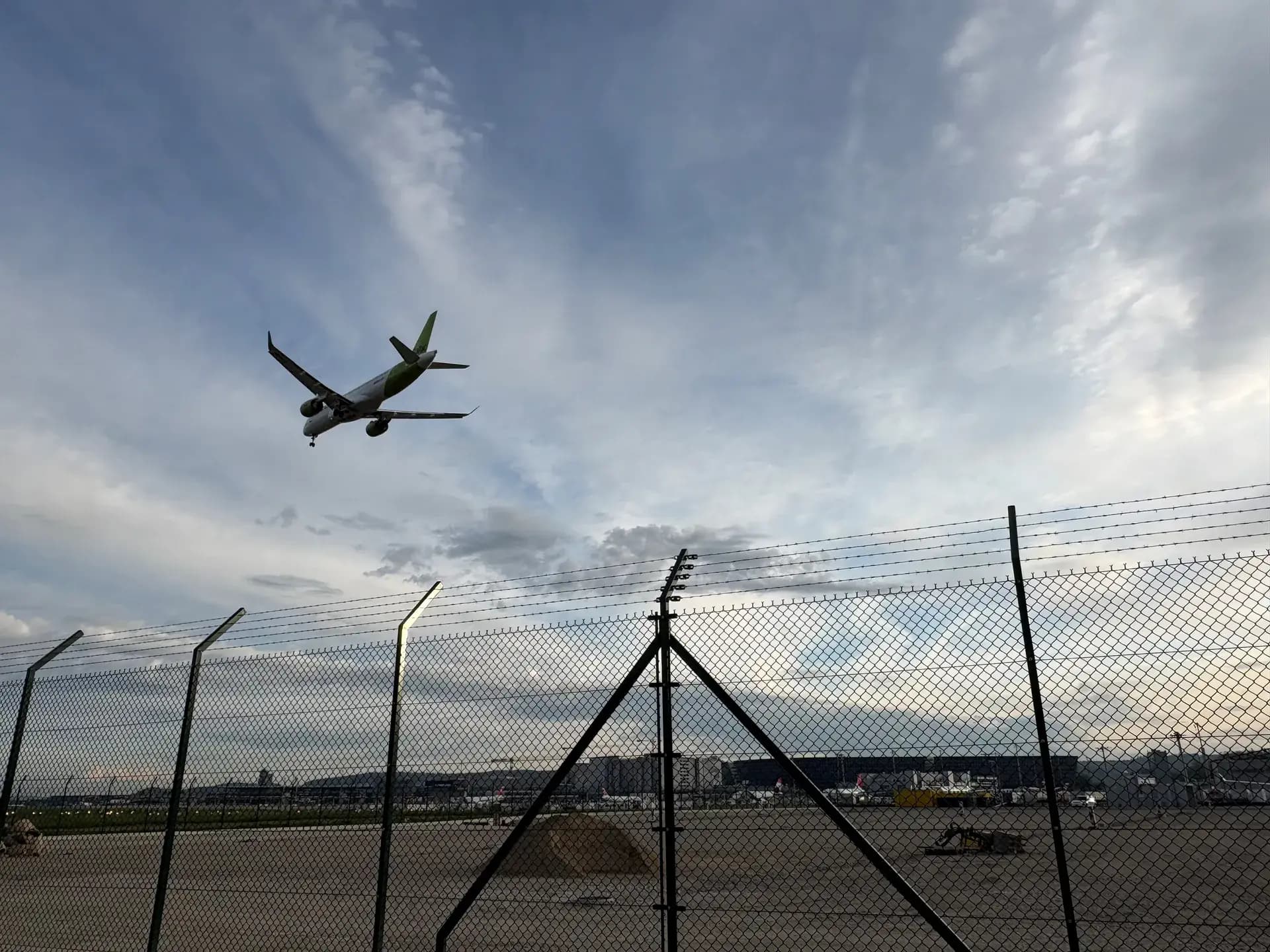 Landendes Flugzeug über dem Flughafenzaun in Kloten
