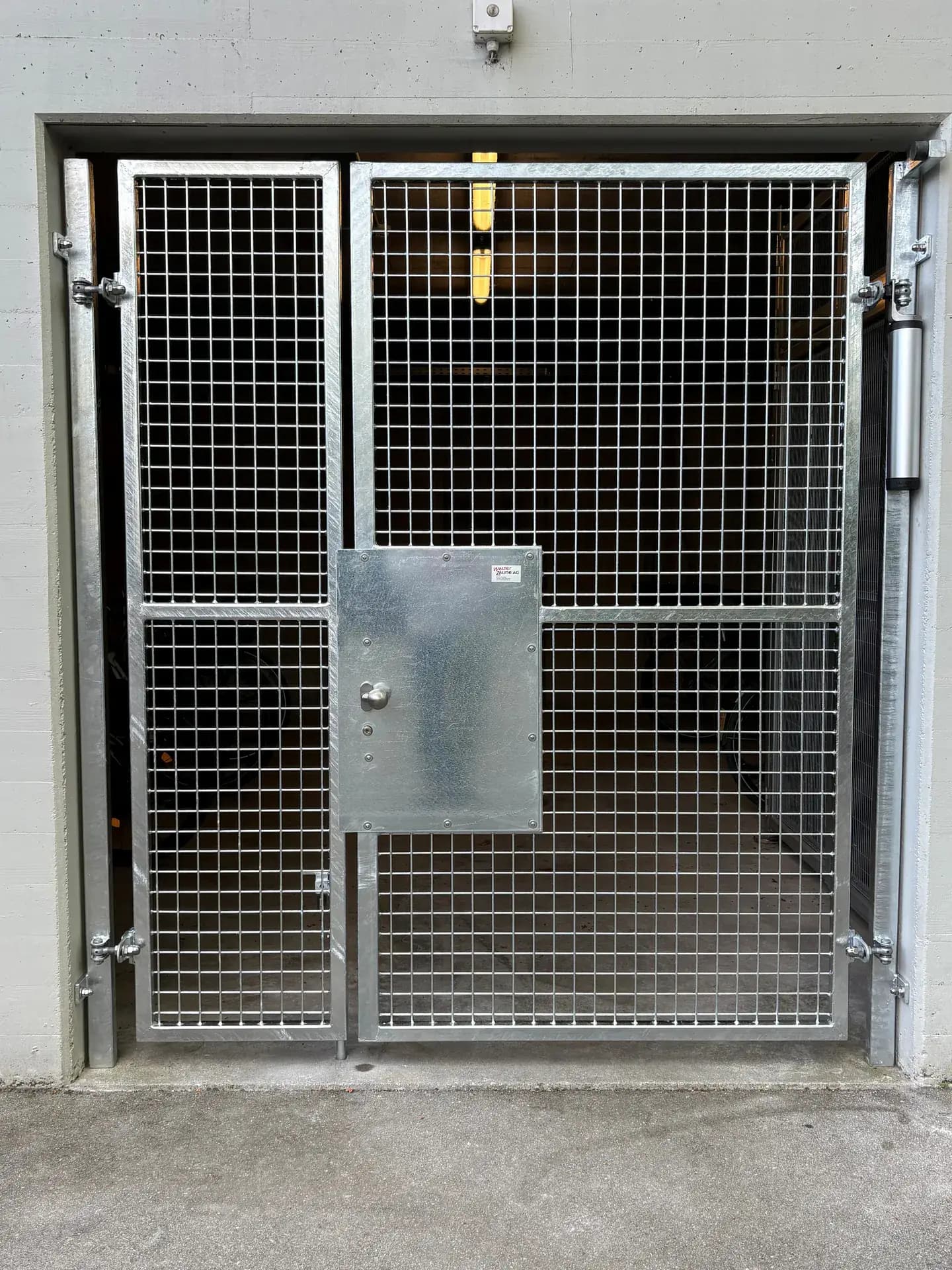Gittertor mit Gitterrost vor einer Tiefgarageneinfahrt