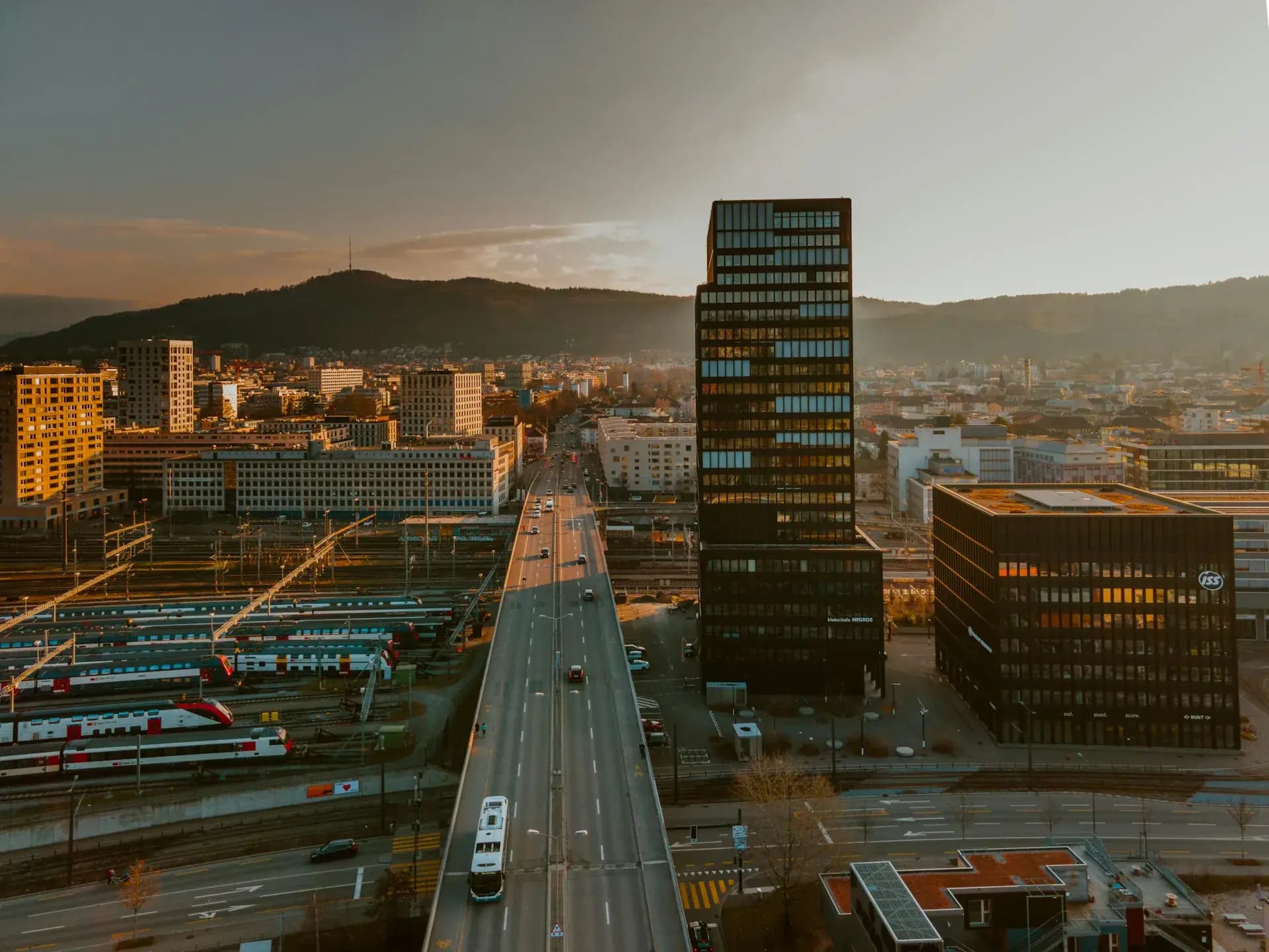 Agglomeration im Abendlicht mit Bahnanlage und Hochhaus